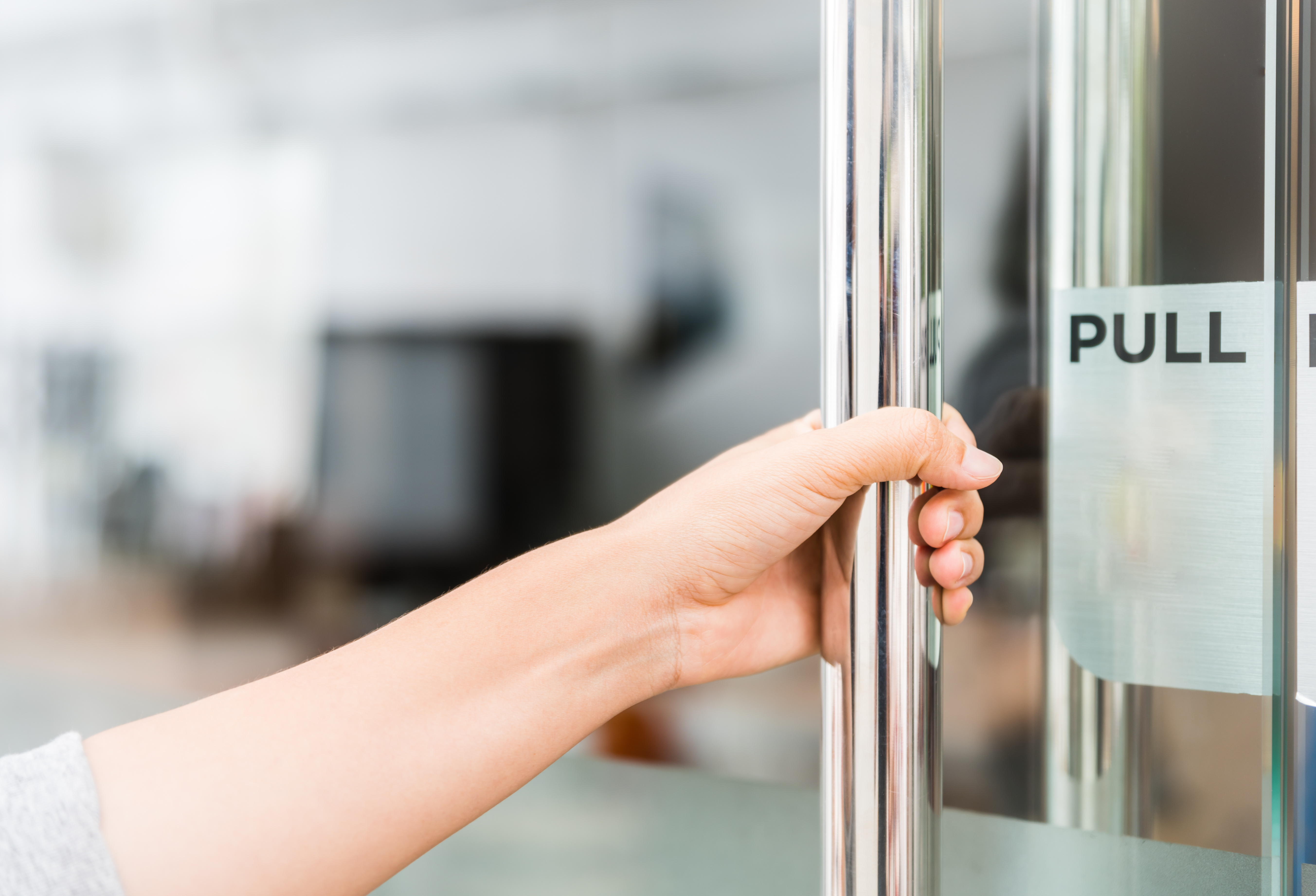A hand grabbing a door handle
