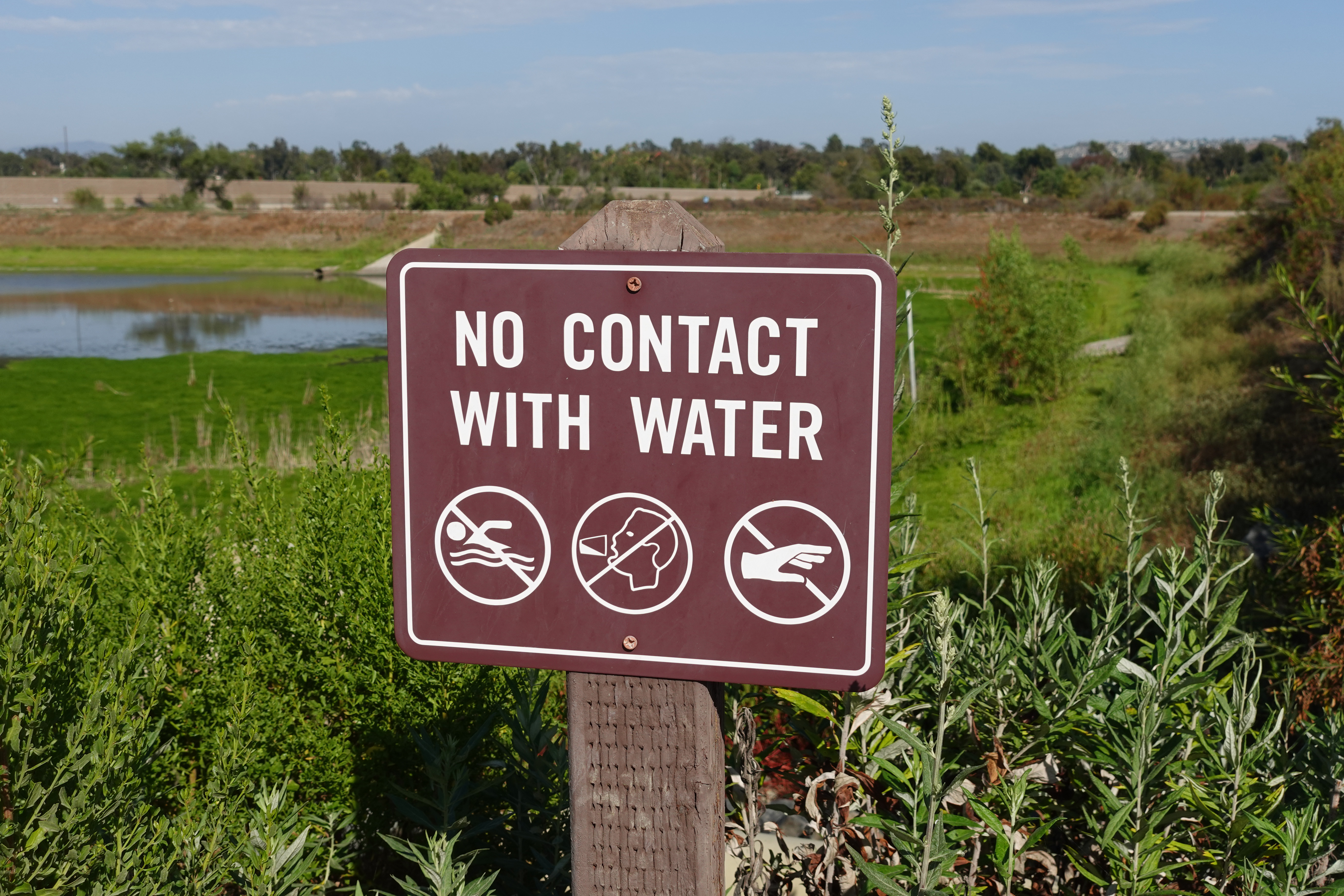 A sign: No Contact With Water, No Swimming, No Drinking, Do Not Touch
