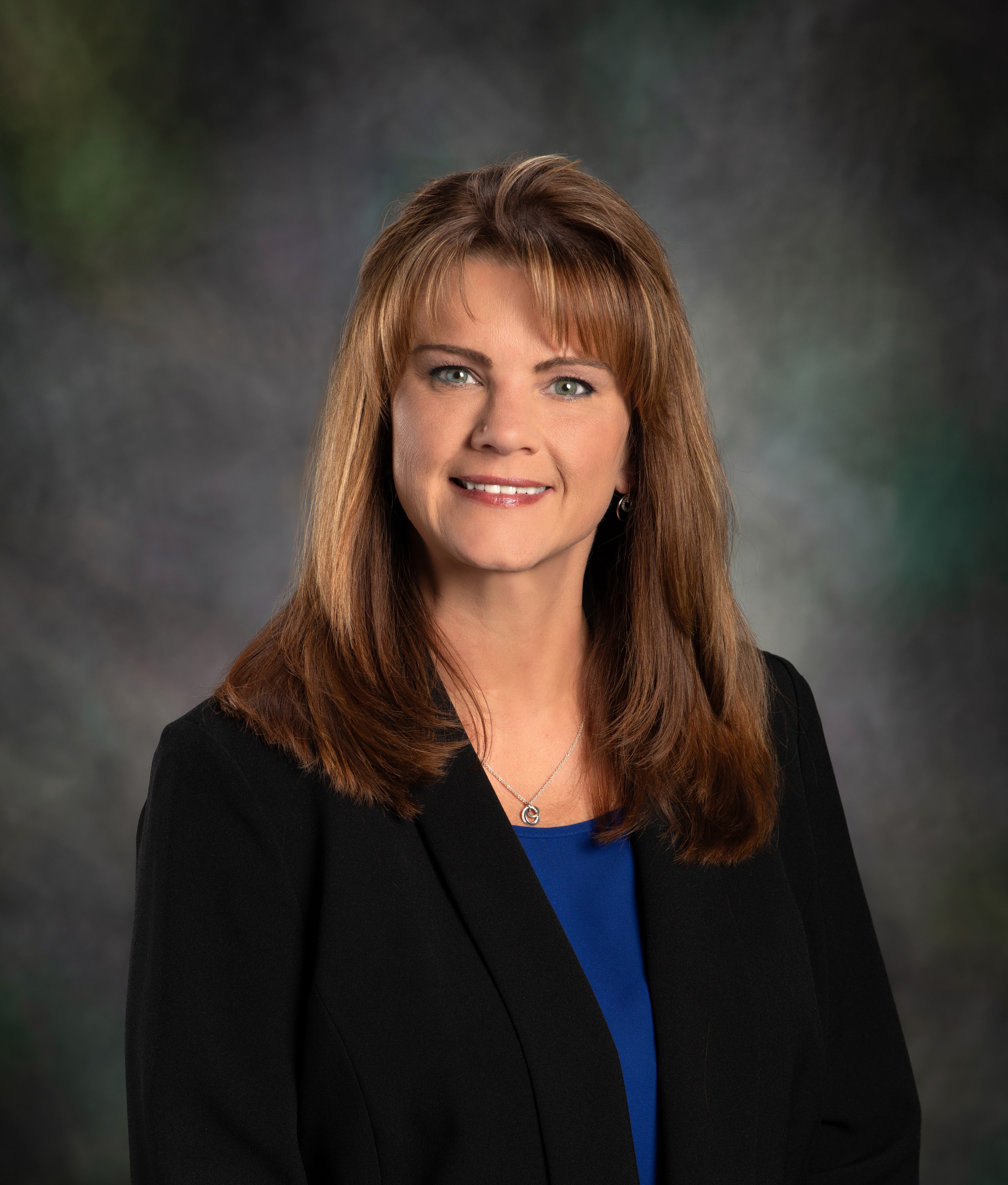 A woman smiling wearing a black blazer