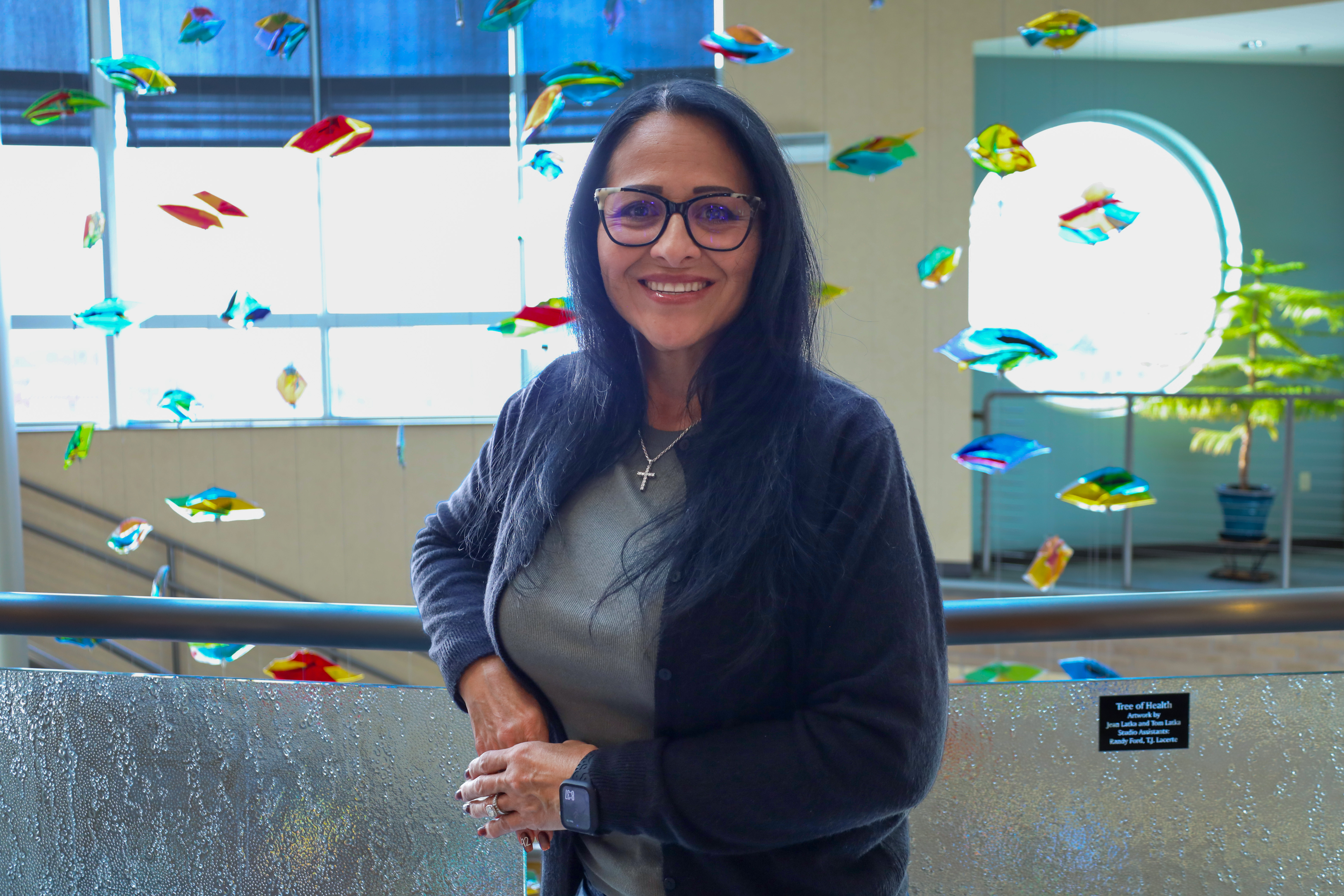 Pam Flores smiling wearing glasses and a black cardigan.